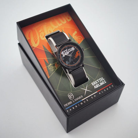 Montre Bretzel Vélo Club – Pierre Lannier x Bretzel Airlines : boîtier noir 40,5 mm, bracelet milanais acier noir, design cycliste alsacien, étanche 50 m, quartz. Édition spéciale Made in France.
